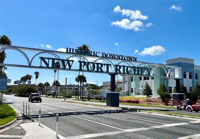 5720 Mockingbird Dr, New Port Richey, FL 34652 - view of asphalt road with curbs, sidewalks, traffic signs, and street lighting