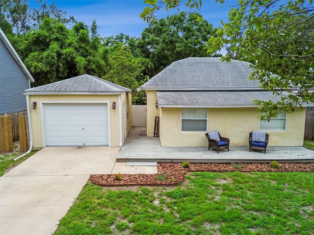 1722 Albemarle Rd, Clearwater, FL 33764 - view of front of property with a shingled roof, a wooden deck, an outbuilding, stucco siding, and a detached garage
