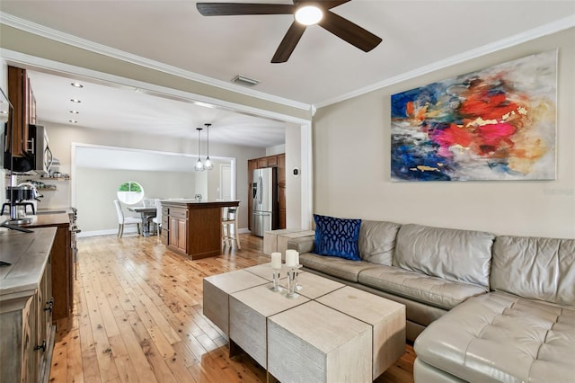 1722 Albemarle Rd, Clearwater, FL 33764 - living room with light wood finished floors, a ceiling fan, and ornamental molding