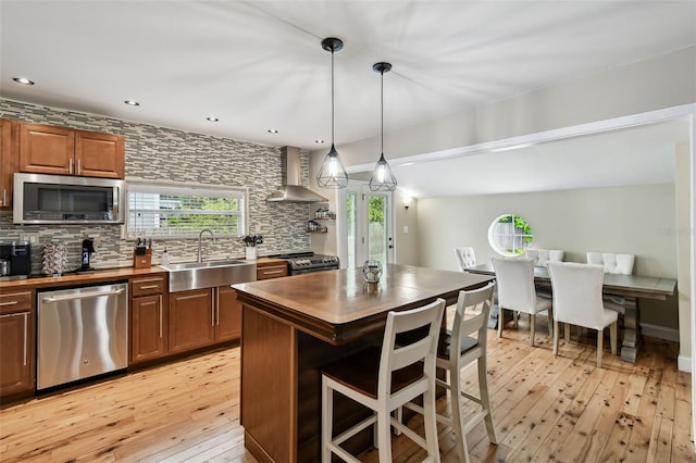 1722 Albemarle Rd, Clearwater, FL 33764 - kitchen featuring appliances with stainless steel finishes, wall chimney exhaust hood, light wood-type flooring, backsplash, and recessed lighting