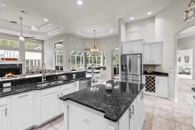 2900 W Lantana Dr, Beverly Hills, FL 34465 - kitchen featuring appliances with stainless steel finishes, open floor plan, a premium fireplace, arched walkways, and a raised ceiling