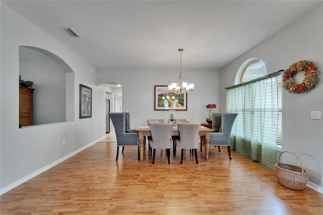 607 Tuscanny St, Brandon, FL 33511 - dining room featuring arched walkways, light wood-type flooring, and a chandelier