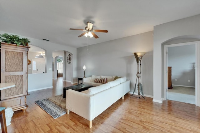 607 Tuscanny St, Brandon, FL 33511 - living area with arched walkways, a ceiling fan, and light wood-type flooring