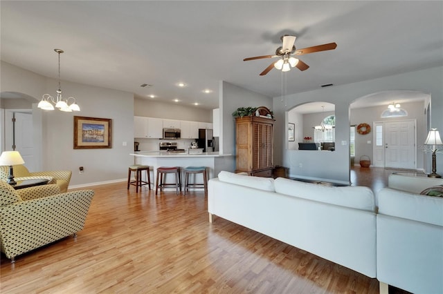 607 Tuscanny St, Brandon, FL 33511 - living area featuring arched walkways, light wood-style floors, a ceiling fan, a chandelier, and recessed lighting