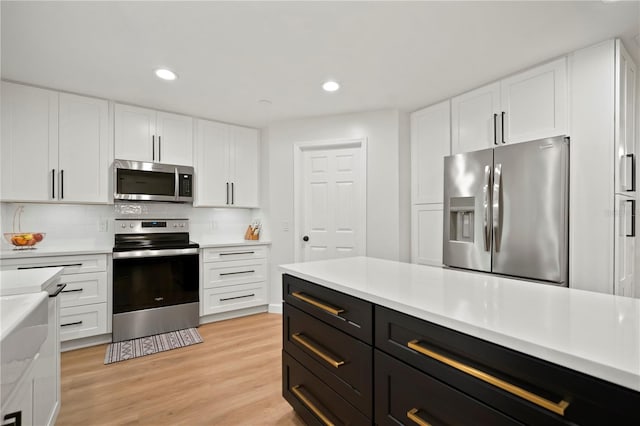 22238 River Rock Dr, Land O Lakes, FL 34639 - kitchen with stainless steel appliances, white cabinets, dark cabinets, light countertops, and recessed lighting