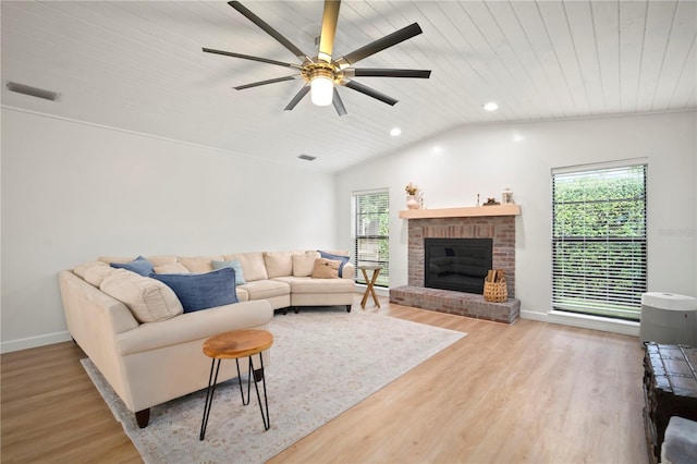 22238 River Rock Dr, Land O Lakes, FL 34639 - living area featuring plenty of natural light, wood finished floors, a brick fireplace, a ceiling fan, and vaulted ceiling