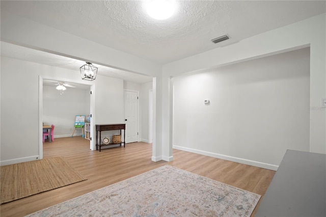 22238 River Rock Dr, Land O Lakes, FL 34639 - basement with wood finished floors, a textured ceiling, and a ceiling fan