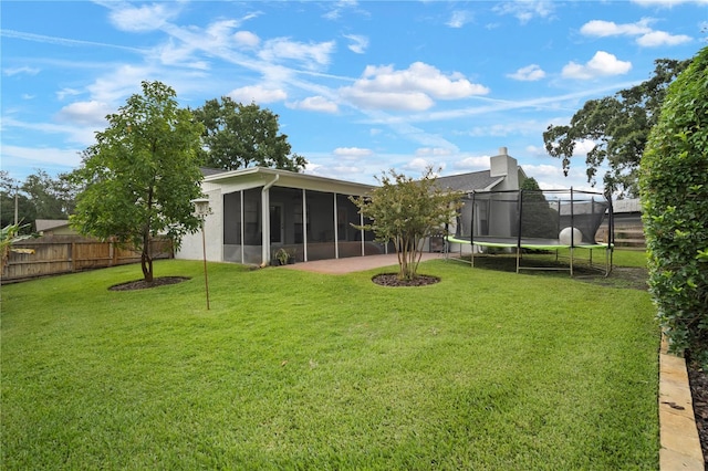 22238 River Rock Dr, Land O Lakes, FL 34639 - rear view of house featuring a trampoline, a sunroom, a fenced backyard, and a chimney