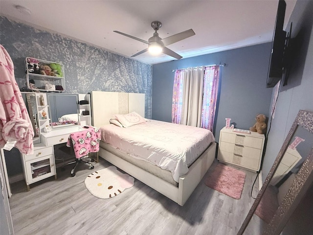 10221 Carloway Hills Dr, Wimauma, FL 33598 - bedroom with wallpapered walls, wood finished floors, an accent wall, and ceiling fan
