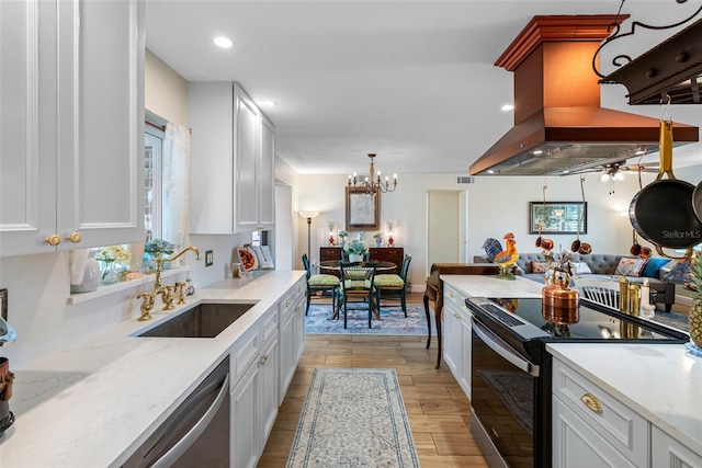 621 77th Ave, St Pete Beach, FL 33706 - kitchen with black electric range, island range hood, white cabinetry, dishwasher, and a chandelier