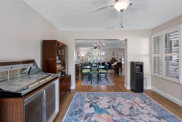 621 77th Ave, St Pete Beach, FL 33706 - dining space with a chandelier, light wood-style floors, and ceiling fan