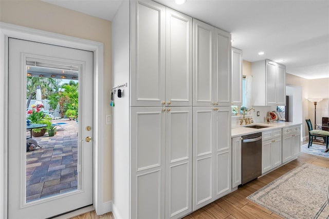 621 77th Ave, St Pete Beach, FL 33706 - kitchen with dishwasher, light countertops, light wood-style floors, white cabinetry, and recessed lighting