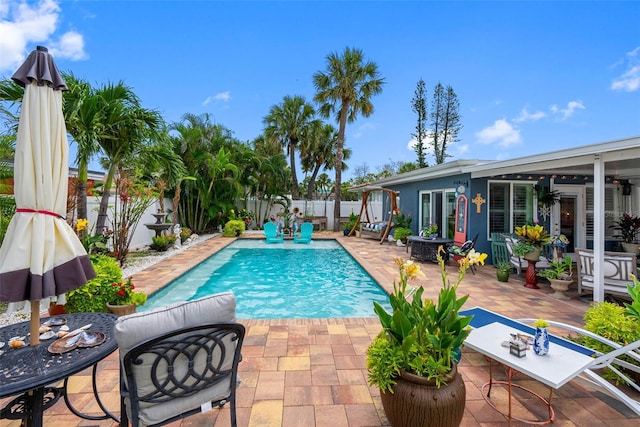 621 77th Ave, St Pete Beach, FL 33706 - view of swimming pool featuring a patio, a fenced backyard, ceiling fan, and outdoor dining area