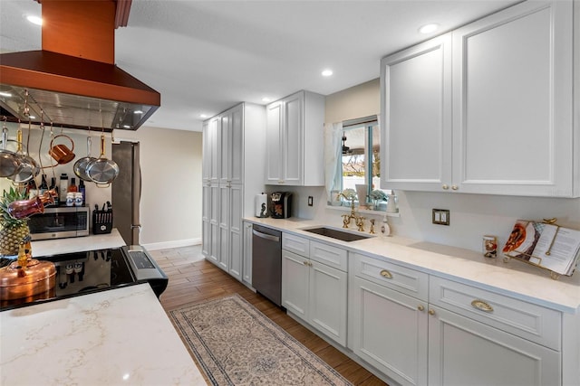 621 77th Ave, St Pete Beach, FL 33706 - kitchen with island range hood, appliances with stainless steel finishes, light wood-type flooring, recessed lighting, and white cabinetry