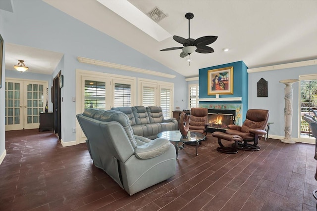 101 Carlyle Dr, Palm Harbor, FL 34683 - living area featuring a ceiling fan, dark wood-style floors, french doors, a lit fireplace, and high vaulted ceiling