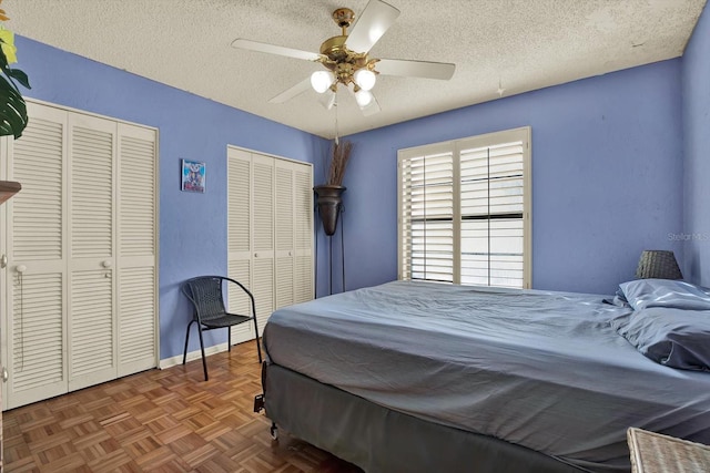 101 Carlyle Dr, Palm Harbor, FL 34683 - bedroom featuring multiple closets, a textured ceiling, and ceiling fan