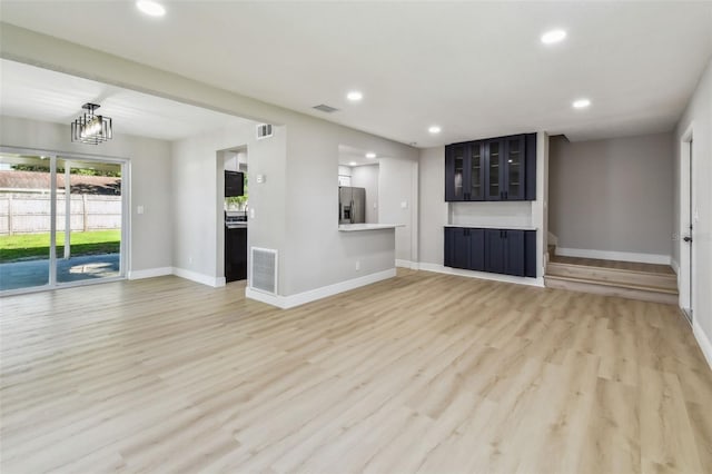 7806 N Matanzas Ave, Tampa, FL 33614 - unfurnished living room with recessed lighting, light wood-style flooring, and a chandelier