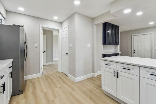 7806 N Matanzas Ave, Tampa, FL 33614 - kitchen with freestanding refrigerator, light wood-style floors, recessed lighting, and white cabinetry