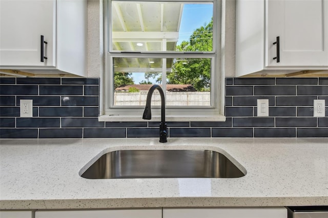 7806 N Matanzas Ave, Tampa, FL 33614 - detailed view of white cabinetry, light stone countertops, and tasteful backsplash