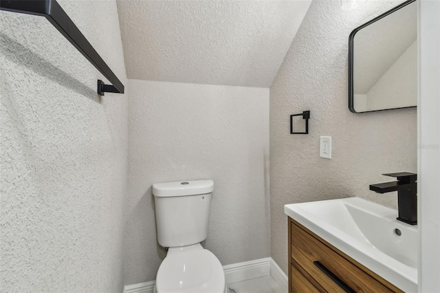 7806 N Matanzas Ave, Tampa, FL 33614 - bathroom featuring lofted ceiling, vanity, a textured wall, and a textured ceiling