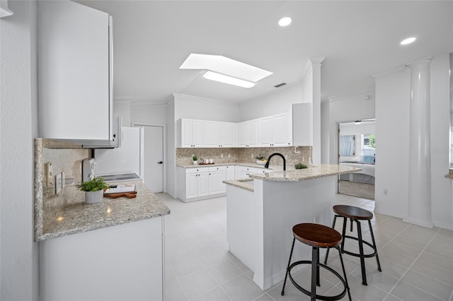 1760 W Shanelle Path, Lecanto, FL 34461 - kitchen with a kitchen breakfast bar, crown molding, tasteful backsplash, a peninsula, and a skylight