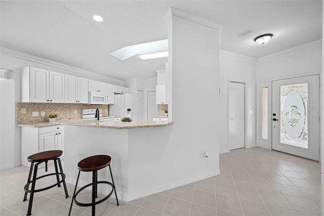 1760 W Shanelle Path, Lecanto, FL 34461 - kitchen with white appliances, a skylight, tasteful backsplash, a kitchen breakfast bar, and crown molding