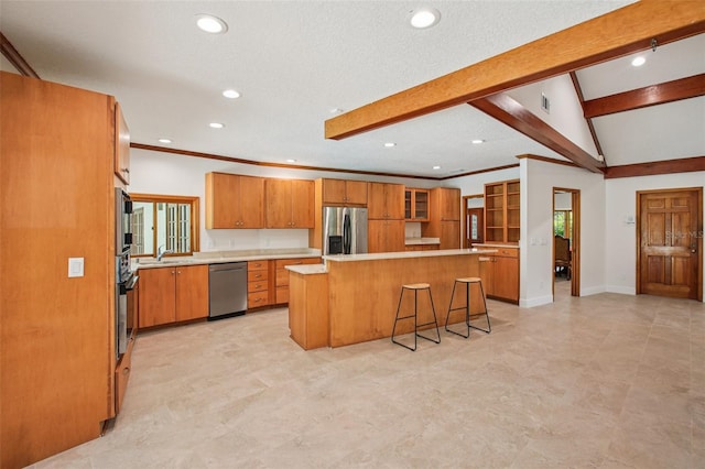 4128 Carrollwood Village Dr, Tampa, FL 33618 - kitchen featuring appliances with stainless steel finishes, brown cabinets, a center island, light countertops, and glass insert cabinets