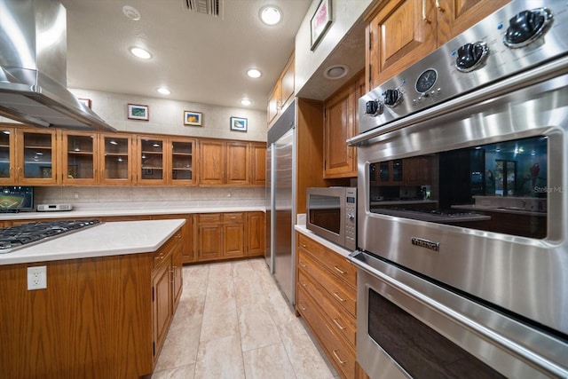 1835 Alicia Way, Clearwater, FL 33764 - kitchen with brown cabinets, island exhaust hood, stainless steel appliances, light countertops, and glass insert cabinets