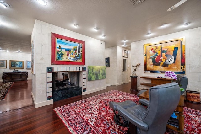 1835 Alicia Way, Clearwater, FL 33764 - living room featuring wood finished floors, a fireplace, a textured ceiling, and tile walls