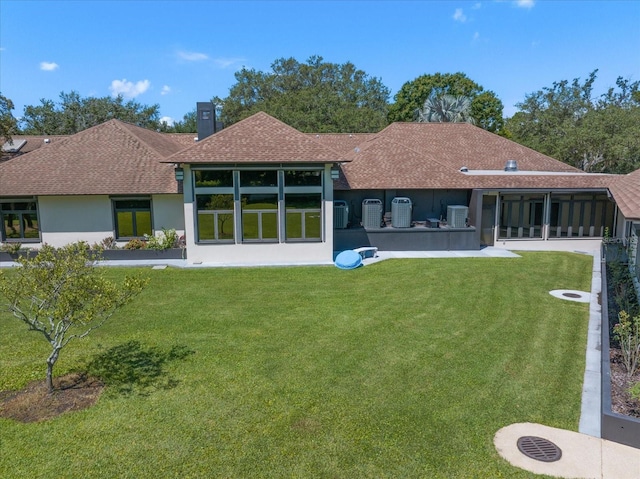 1835 Alicia Way, Clearwater, FL 33764 - rear view of house featuring roof with shingles, a lawn, a sunroom, and stucco siding