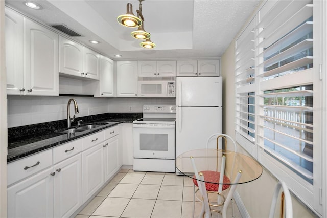 920 Virginia St Unit 204, Dunedin, FL 34698 - kitchen with white appliances, white cabinetry, decorative backsplash, dark stone countertops, and light tile patterned flooring