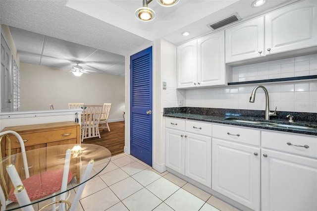 920 Virginia St Unit 204, Dunedin, FL 34698 - kitchen featuring ceiling fan, white cabinets, dark stone countertops, decorative backsplash, and light tile patterned floors