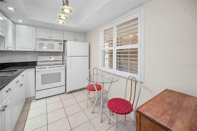 920 Virginia St Unit 204, Dunedin, FL 34698 - kitchen featuring white appliances, white cabinetry, decorative backsplash, light tile patterned flooring, and a tray ceiling