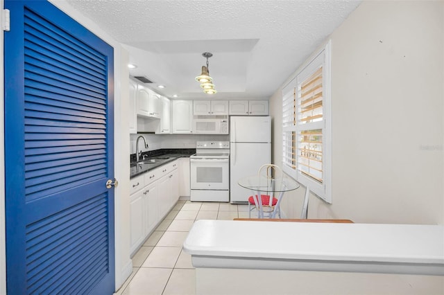 920 Virginia St Unit 204, Dunedin, FL 34698 - kitchen featuring white appliances, light tile patterned floors, white cabinets, a textured ceiling, and decorative light fixtures