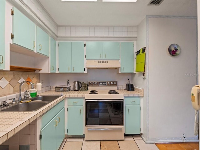 2357 Walton Cir Unit M6, Palm Harbor, FL 34683 - kitchen featuring premium range hood, white electric stove, light countertops, light tile patterned flooring, and decorative backsplash