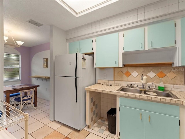 2357 Walton Cir Unit M6, Palm Harbor, FL 34683 - kitchen with freestanding refrigerator, light tile patterned flooring, and tasteful backsplash