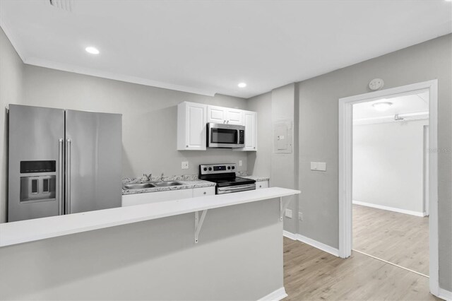 271 Eastpoint Ct, Spring Hill, FL 34606 - kitchen with stainless steel appliances, light countertops, light wood-type flooring, white cabinetry, and recessed lighting