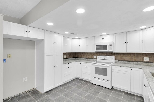 271 Eastpoint Ct, Spring Hill, FL 34606 - kitchen with white appliances, decorative backsplash, white cabinetry, recessed lighting, and light tile patterned floors