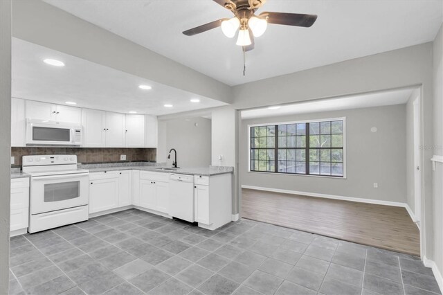 271 Eastpoint Ct, Spring Hill, FL 34606 - kitchen with white appliances, backsplash, light tile patterned flooring, light countertops, and white cabinetry