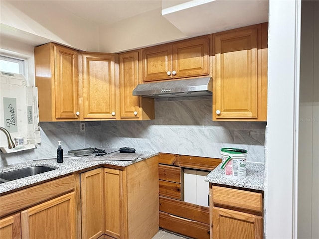 6711 Arroyo Dr, New Port Richey, FL 34652 - kitchen with under cabinet range hood, backsplash, light stone countertops, and brown cabinets