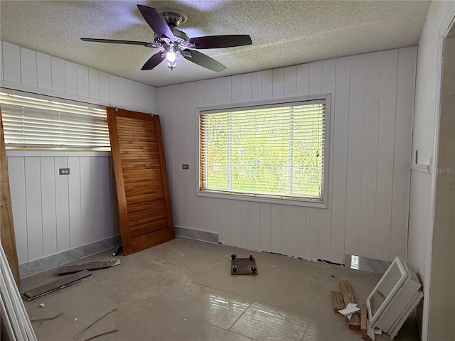 6711 Arroyo Dr, New Port Richey, FL 34652 - unfurnished bedroom featuring a textured ceiling, ceiling fan, and wooden walls