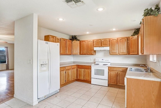 7841 Royal Stewart Dr, New Port Richey, FL 34653 - kitchen with white appliances, light tile patterned flooring, under cabinet range hood, light countertops, and recessed lighting