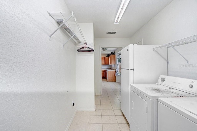 7841 Royal Stewart Dr, New Port Richey, FL 34653 - laundry area featuring washing machine and clothes dryer and light tile patterned flooring