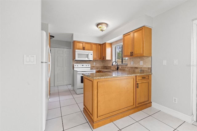 1724 Adams Cir S, Largo, FL 33771 - kitchen with white appliances, a peninsula, decorative backsplash, light tile patterned flooring, and light stone counters