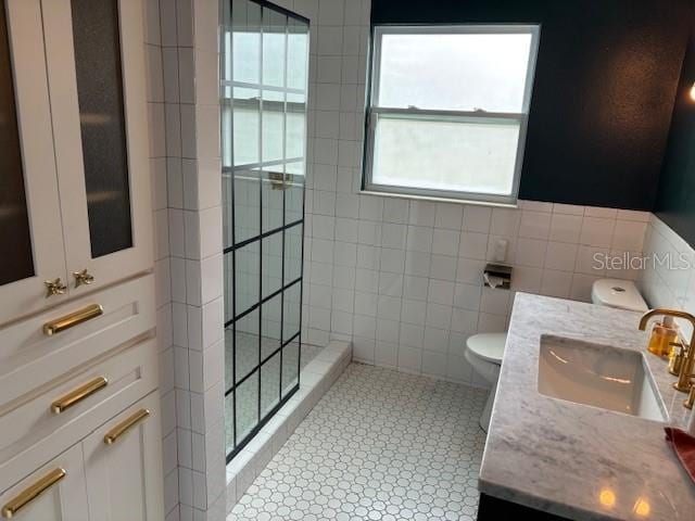1601 14th St N, Saint Petersburg, FL 33704 - bathroom featuring tile walls, walk in shower, vanity, and tile patterned flooring