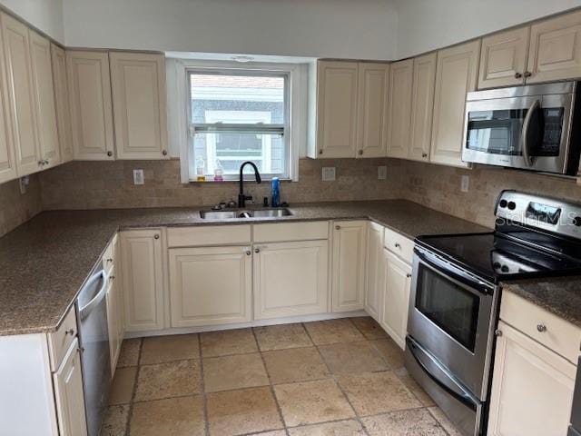 1601 14th St N, Saint Petersburg, FL 33704 - kitchen featuring appliances with stainless steel finishes, tasteful backsplash, stone tile flooring, and cream cabinetry