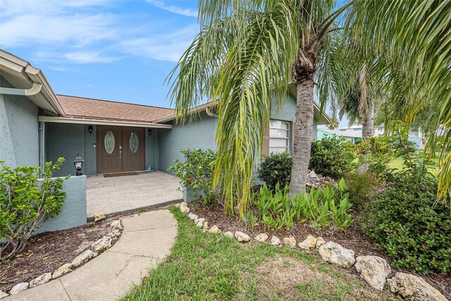 15525 Old Dixie Hwy, Hudson, FL 34667 - view of exterior entry with stucco siding and roof with shingles