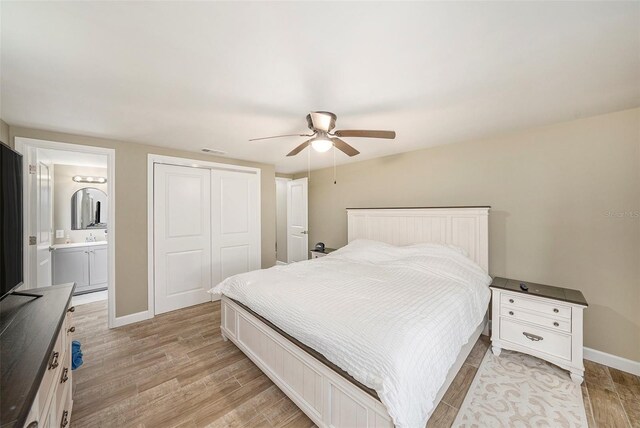 15525 Old Dixie Hwy, Hudson, FL 34667 - bedroom featuring a closet, light wood-style flooring, ensuite bathroom, and a ceiling fan