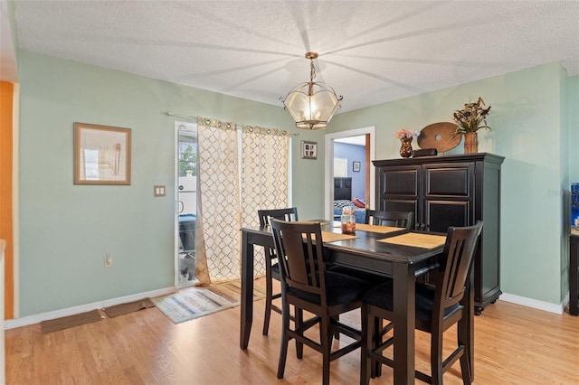 9171 Horizon Dr, Spring Hill, FL 34608 - dining space with light wood-style flooring, a chandelier, and a textured ceiling