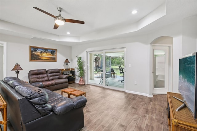 14509 Mayer Ave, Hudson, FL 34669 - living room with a tray ceiling, a ceiling fan, wood finished floors, arched walkways, and recessed lighting